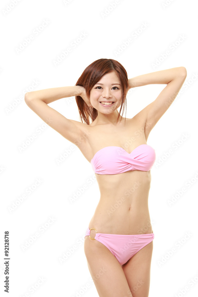 Japanese woman posing in a pink bikini Photos | Adobe Stock