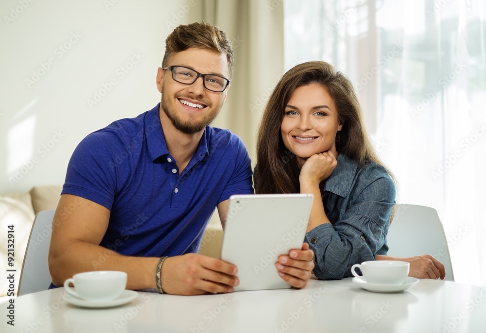 Cheerful couple with tablet pc at home