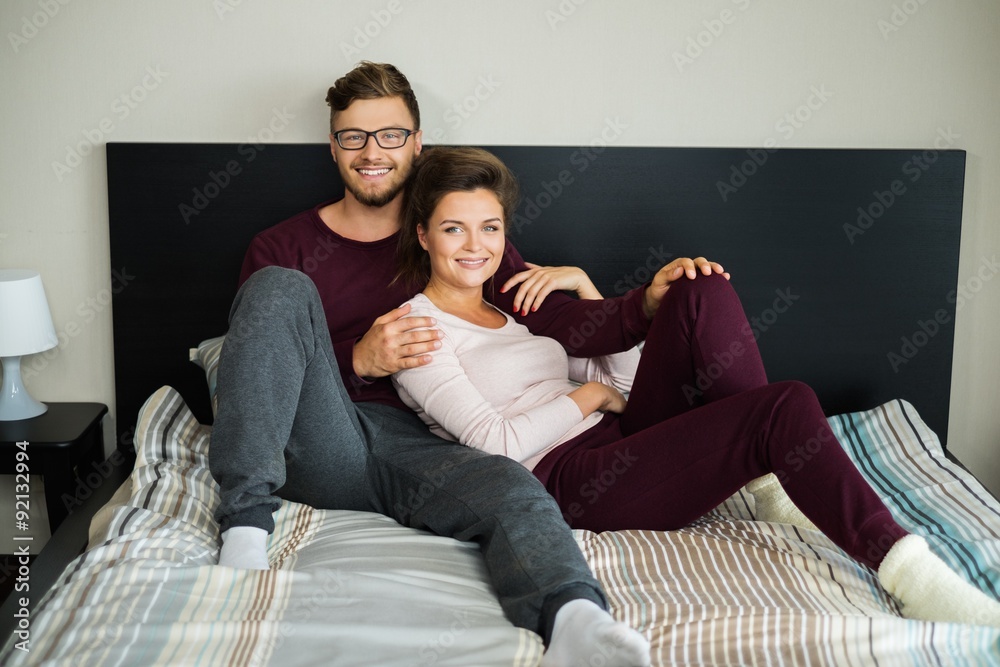 Cheerful couple on a bed at home Cheerful couple on a bed at home