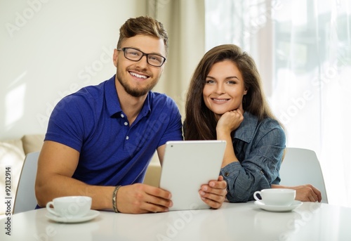 Cheerful couple with tablet pc at home