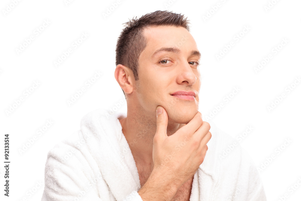 Freshly shaved young man in a white bathrobe Freshly shaved young man in a white bathrobe