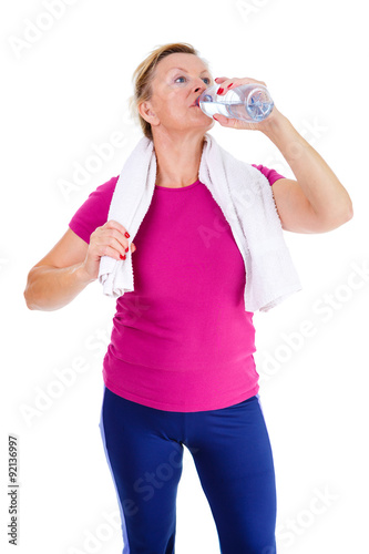 Image of old senior woman in sport outfit with white towel on her neck drinking water, isolated on white background, Positive human emotions