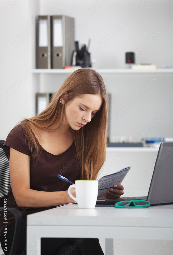 Portrait of young business woman working at her office. Portrait of young business woman working at her office.
