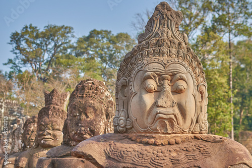 Statues of ancient khmer warrior heads carry giant snake decorating bridge to Bayon at Angkor Wat complex  Siem Reap  Cambodia.