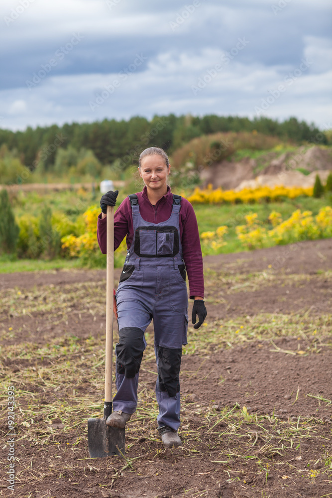 Fototapeta premium Woman gardener digging earth