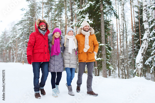 group of smiling men and women in winter forest