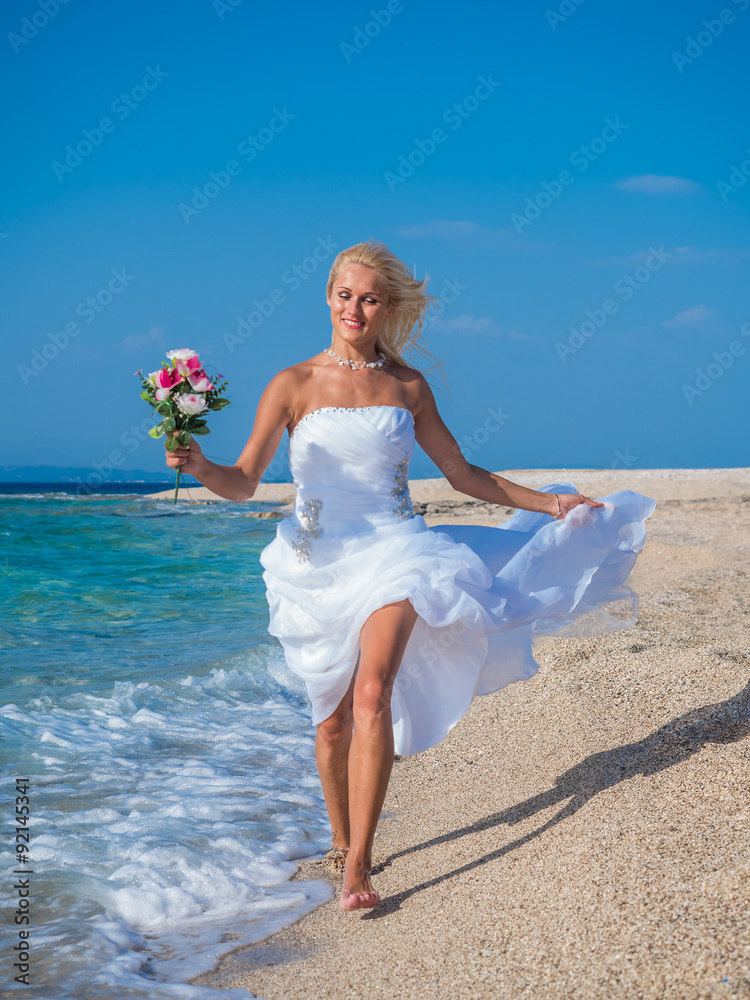 Young bride in wedding drees having fun on the beach Young bride in wedding drees having fun on the beach