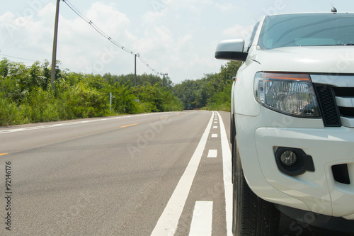 Close up front of new white car parking on the asphalt road