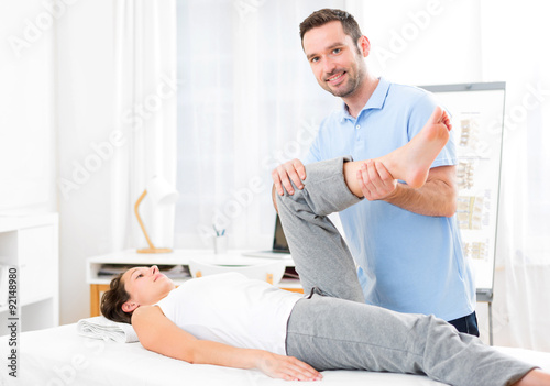 Young attractive woman being manipulated by physiotherapist photo