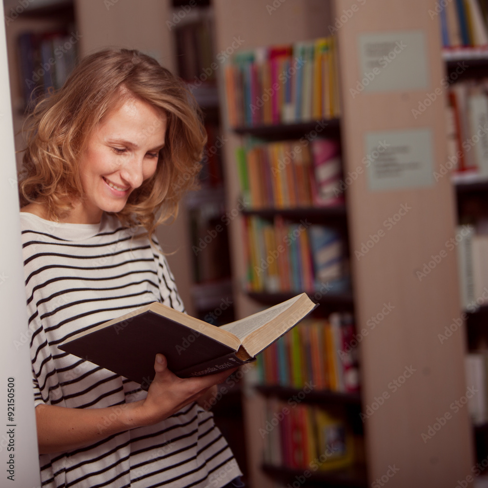 In the library, student girl or young woman with books thinking In the library, student girl or young woman with books thinking