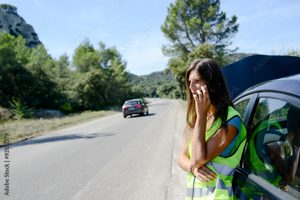 young woman with car breakdown on the roadside calling insurance company for assistance young woman with car breakdown on the roadside calling insurance company for assistance