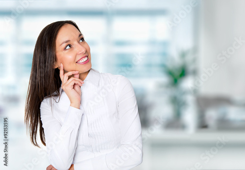 Smiling businesswoman in formalwear sitting at workplace