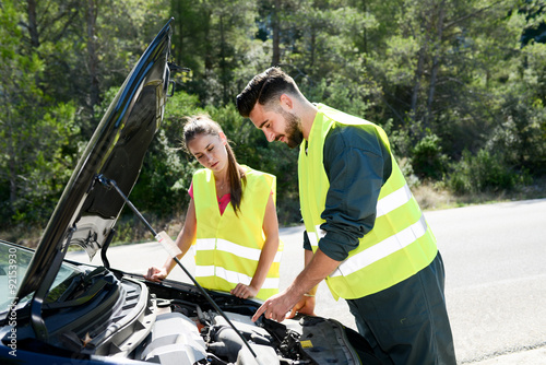 Fotografi young woman and mechanic assistance on roadside with car breakdown
