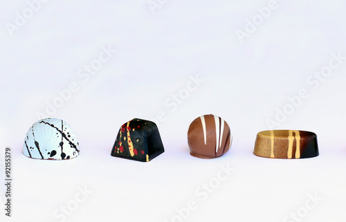 Four chocolate bonbons on white background