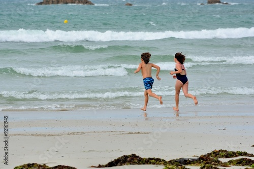 Vászonkép Deux enfants courent vers la mer sur une plage en Bretagne à Trestel