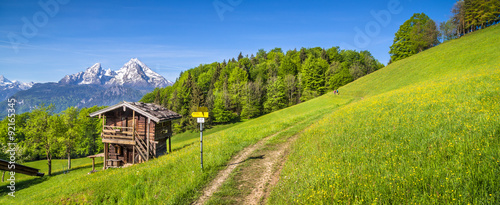 Idyllic mountain scenery in the Alps with hiking trail and mountain chalet