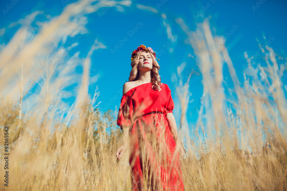 Obraz premium Girl in the Red Dress is Walking on the Field