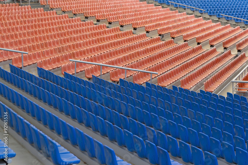 Rows of blue and orange plastic seats on stadium