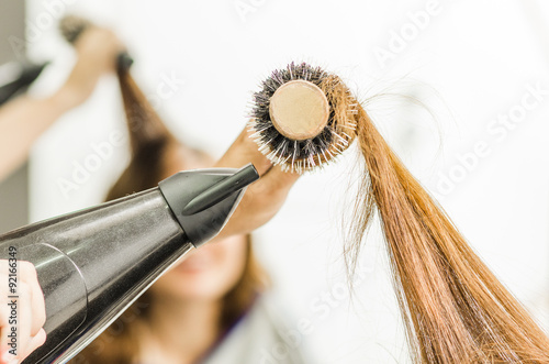 Closeup hairbrush with brunette hair swirled around and black