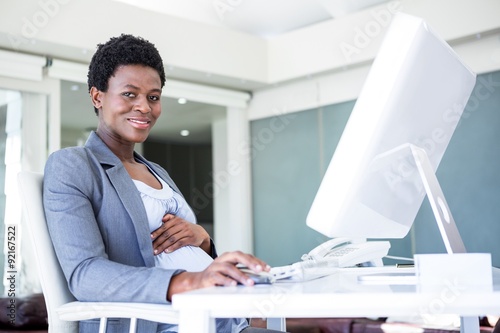 Smiling pregnant businesswoman at work photo