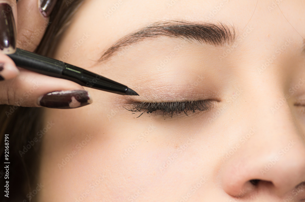 Closeup headshot brunette getting makeup treatment by