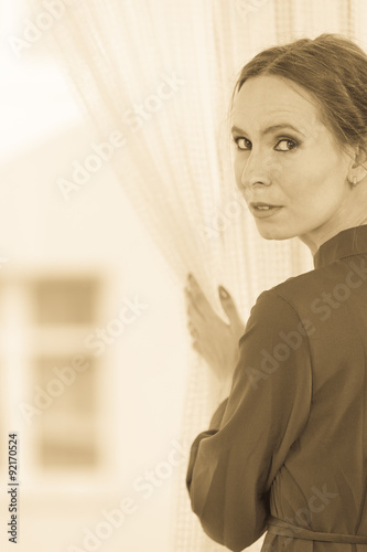 woman looking through window waiting