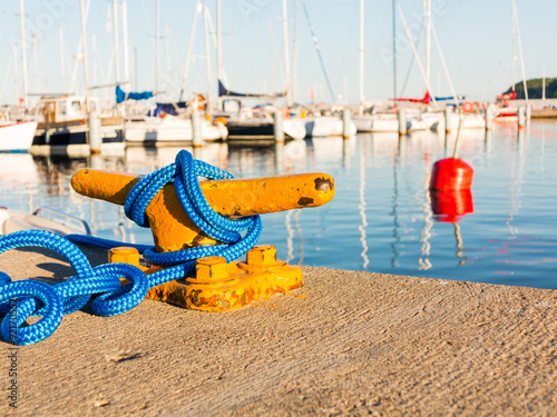 Fototapeta Naklejka Na Ścianę i Meble -  Mooring bollard with rope on pier by the sea