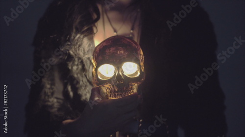 handssome magical pirate holding a death's head illuminated from inside by candle in 4K