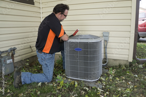 Repairman Checking Outside Air Conditioning Unit For Voltage photo