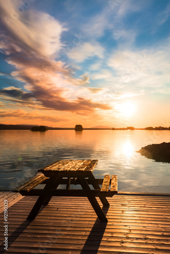 bench on a wooden pier at sunset