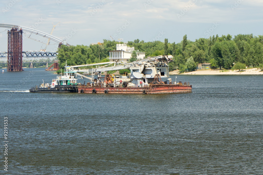Floating crane towed along the river Dnieper