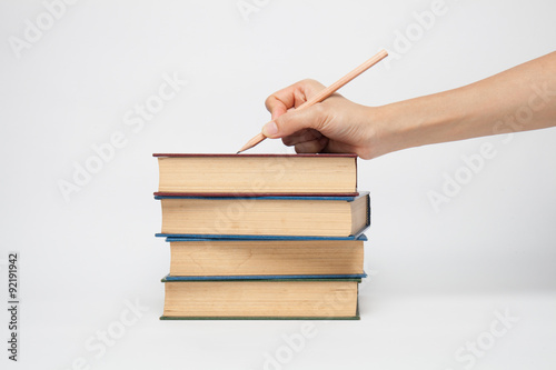 Woman's hand holding a pencil on a white white background