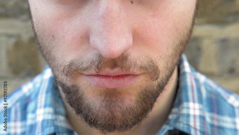 Extreme close up shot of young guy inhaling an electronic cigarette and exhaling the vapour. He is outside standing in front of a brick wall. Naturally lit footage. Extreme close up shot of young guy inhaling an electronic cigarette and exhaling the vapour. He is outside standing in front of a brick wall. Naturally lit footage.