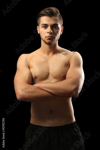 Muscle young man on dark ba...