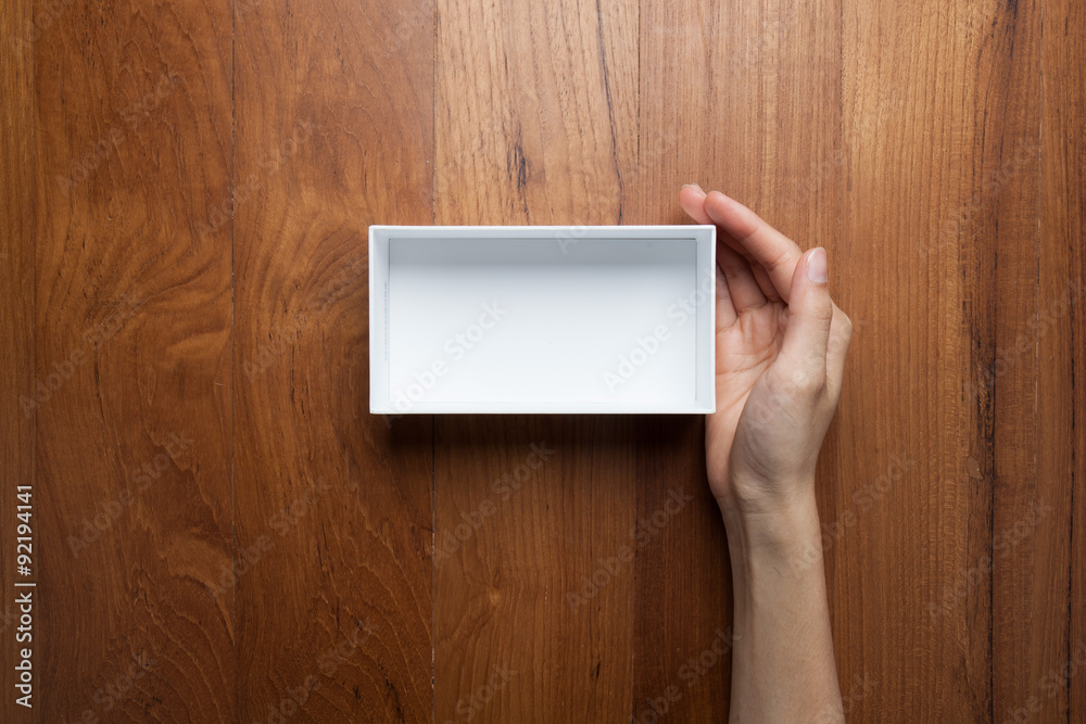 A female(woman, girl) a hand hold the empty(blank) white box, to A female(woman, girl) a hand hold the empty(blank) white box, to
