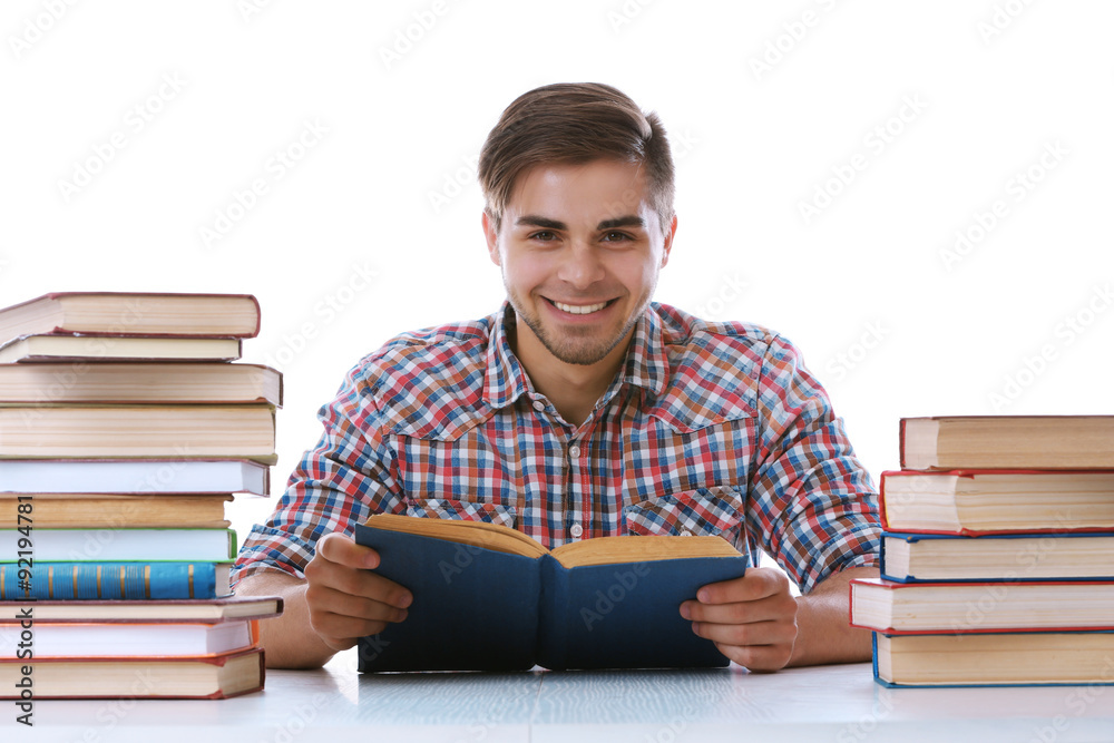 Young man reading book at table on white background Young man reading book at table on white background