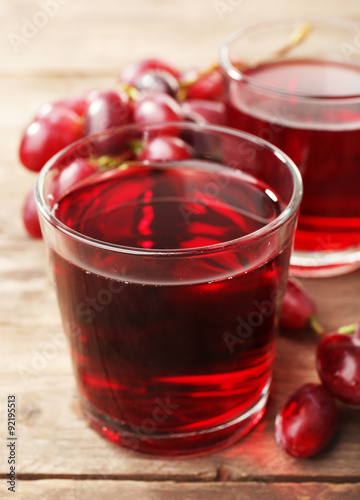 Glass of grape juice on wooden table, closeup