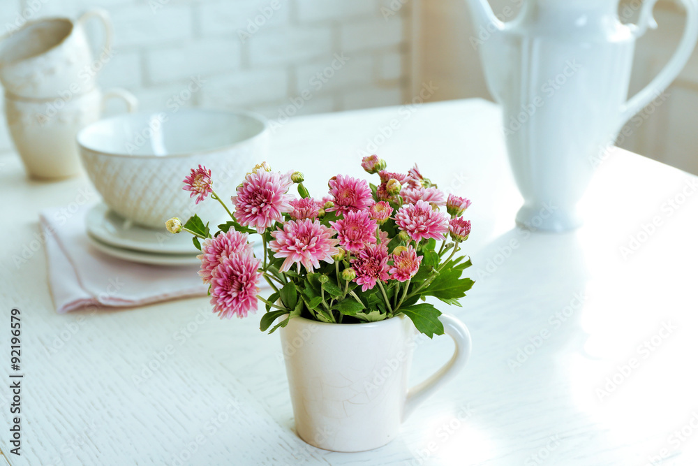 Beautiful flowers in decorative vase on table, on light background Beautiful flowers in decorative vase on table, on light background