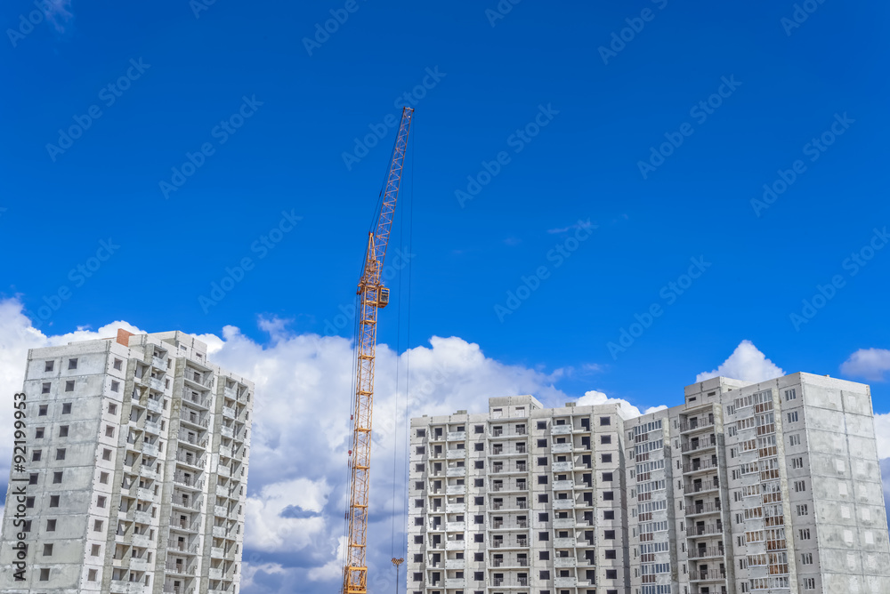 Fototapeta premium Construction of high-rise houses and building crane