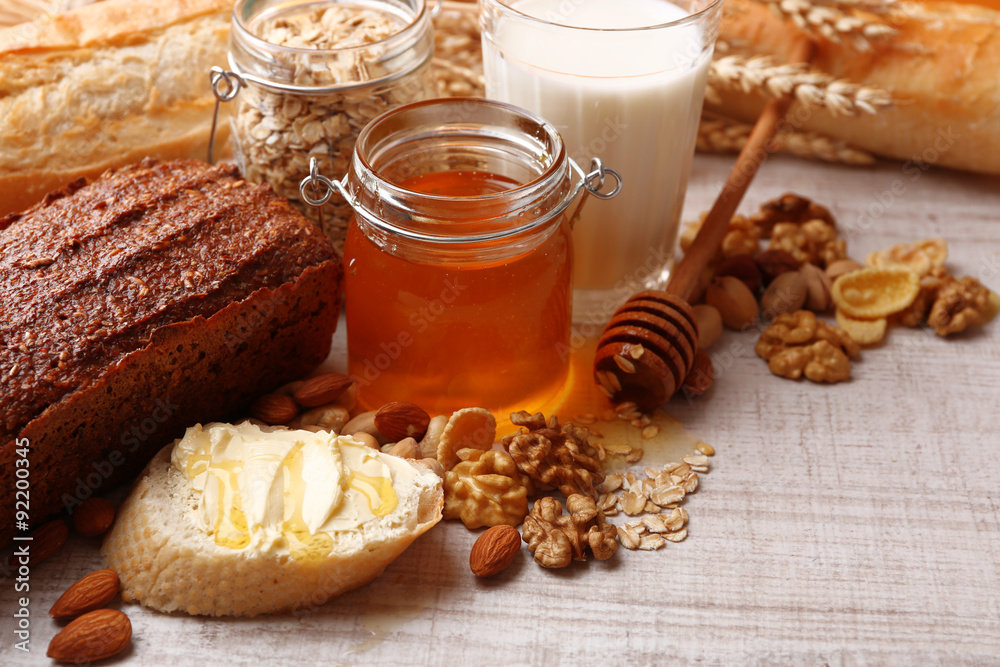 Healthy breakfast with bread, honey, nuts on table, on colorful background. Country breakfast concept