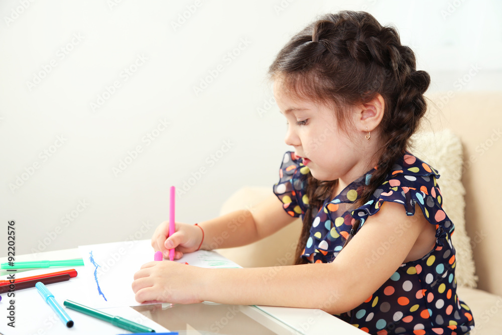 Cute little girl drawing picture on home interior background Cute little girl drawing picture on home interior background