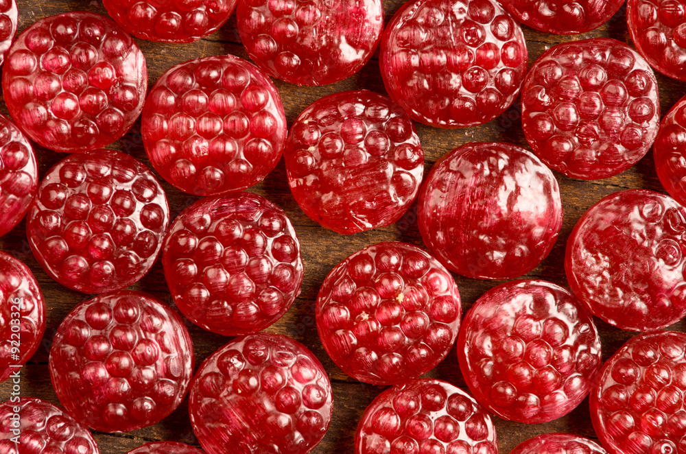 Pile of tasty delicious raspberry hard candy lying on wooden Pile of tasty delicious raspberry hard candy lying on wooden