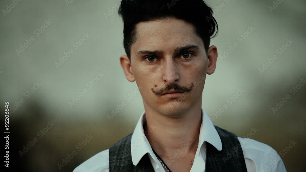 a young man with a mustache looking at you