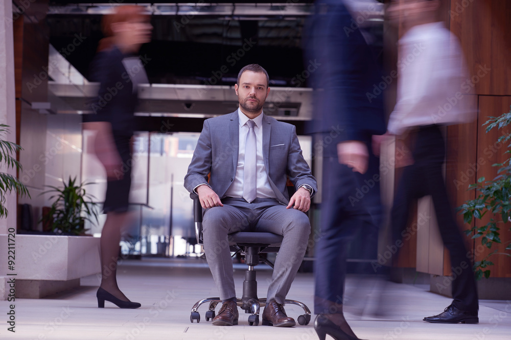 Obraz premium business man sitting in office chair, people group passing by