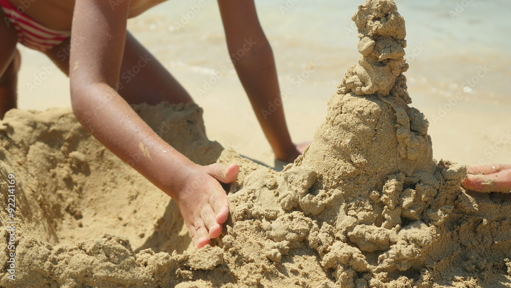 Family playing on the beach building sand castle. 4K UHD.
