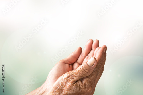 Two open empty hands of old woman with blur background