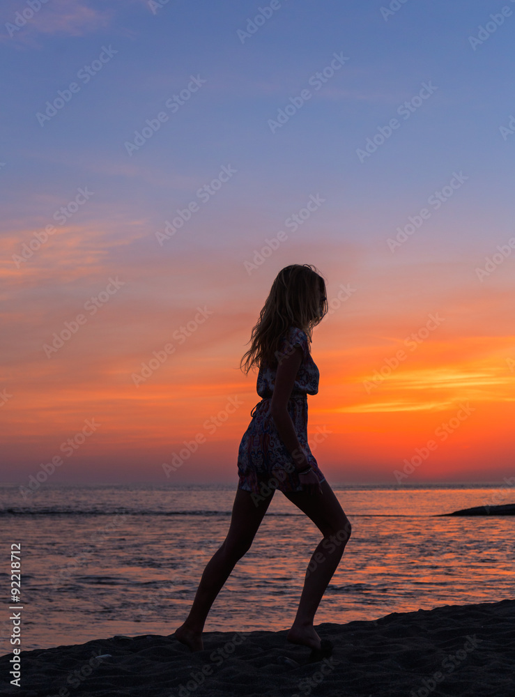 Beautiful young woman on the beach sunset