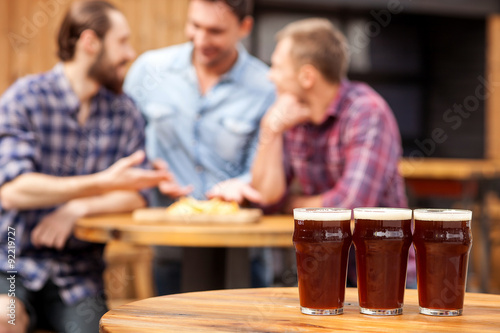 Cheerful young guys are communicating in pub