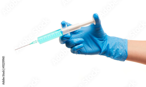 Close up of female doctor's hand in blue sterilized surgical glove with plastic medical syringe filled with blue drug against white background