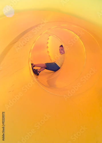 happy kid in a tube slide
